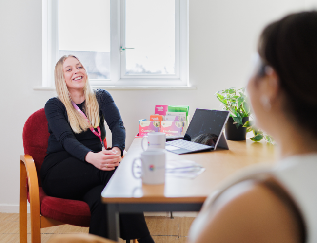 One Manchester colleague laughing with a customer 
