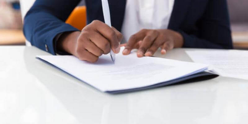 Photo of a person signing paperwork
