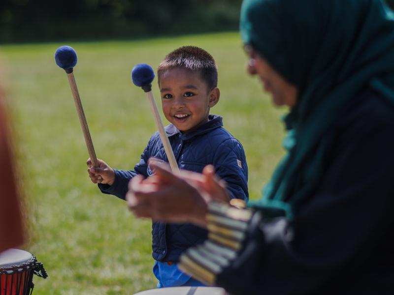 a boy playing drums at a summer event