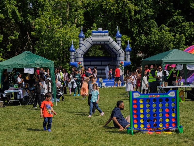 a landscape photo of a summer event with bouncy castle and activity stalls