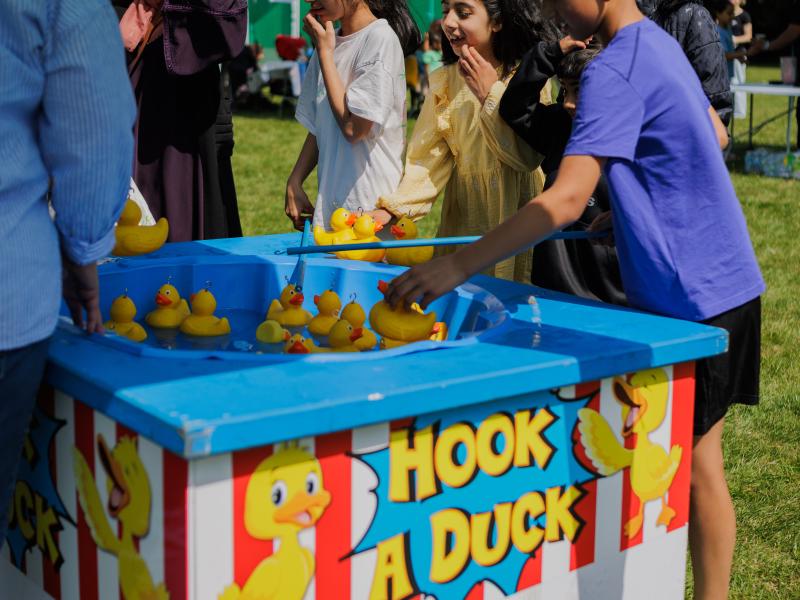 children playing hook a duck at a summer event
