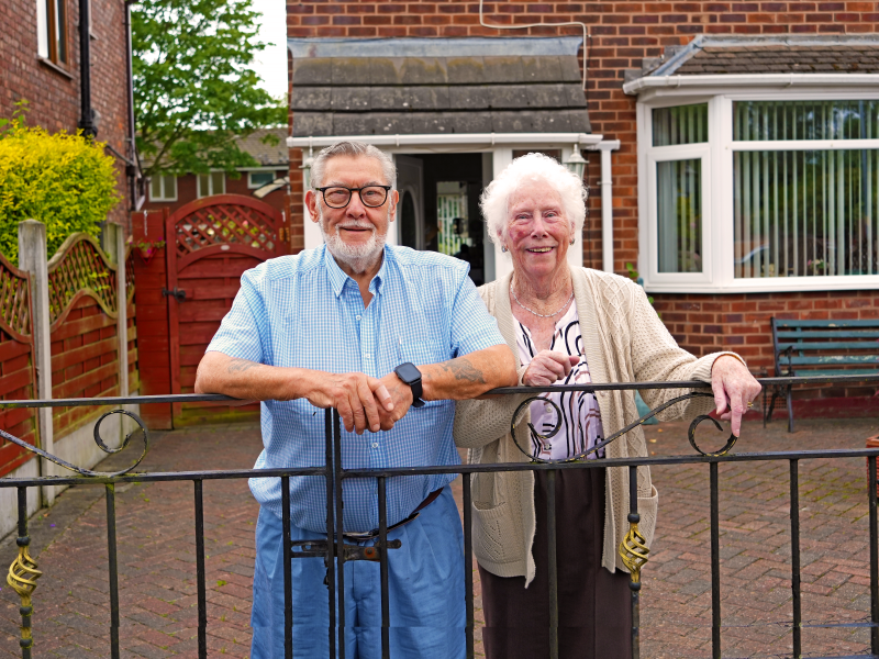 Older couple outside their home