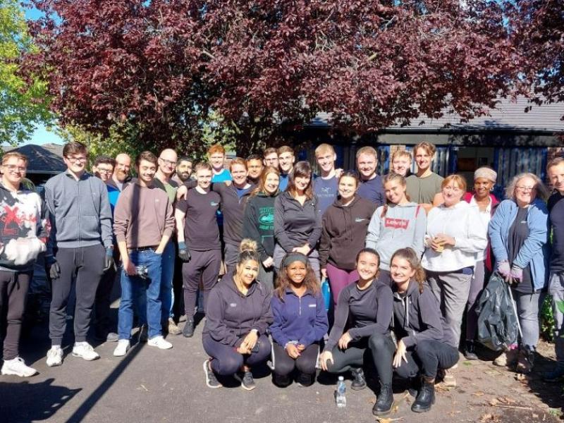 A picture containing volunteers standing in a garden. 