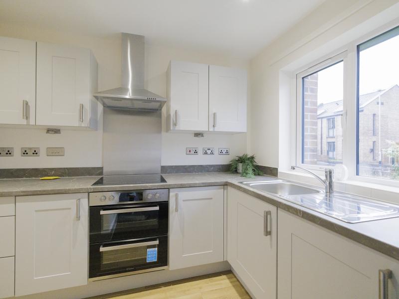 A brand new kitchen in an L shape with a window on to the garden.