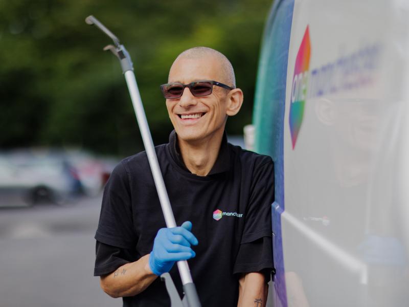 One Manchester colleague holding a litter picker next to One Manchester van