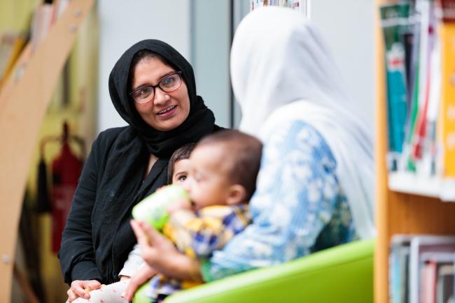 Two women talking with child