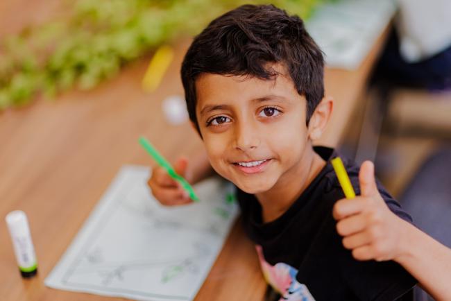 Child doing colouring at a community fun event