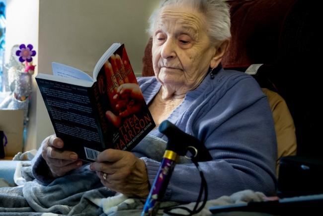 Elderly person sitting reading